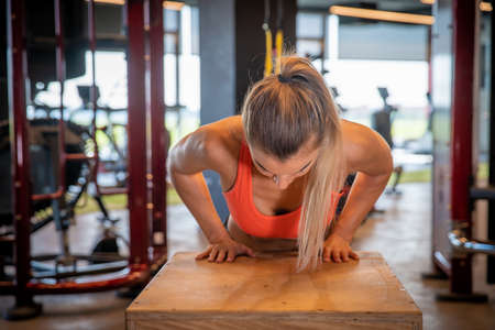 Young woman practicing cranks on wooden crates in a gym.の写真素材