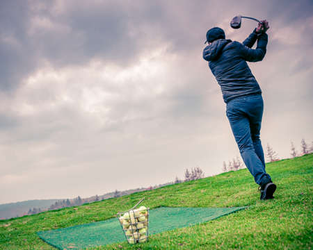 Batting golf balls on a grassy field at the tournament in the fallの写真素材