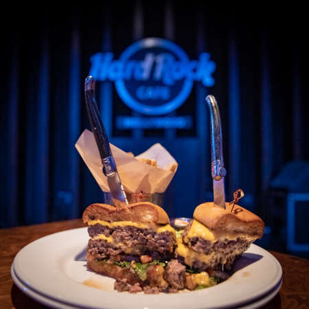Los Angeles - september 5, 2019: Hamburger on table with Hard Rock Cafe logo in backgroundのeditorial素材