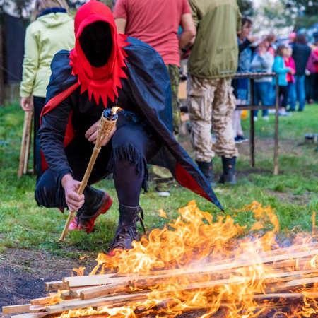 executioner lights a torch by the fire for burning the witch.の写真素材