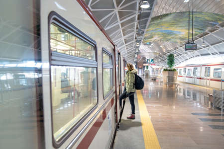 woman boarding a train with a respirator on her head. Protection against viral diseases in public...