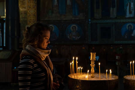 woman in the church prays before candles, worshipの写真素材
