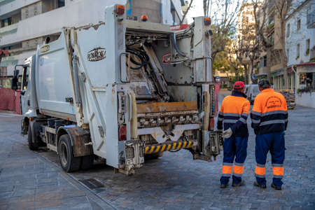 Marbella - January 16, 2020: collecting waste from a container by a special car in the streets of a...