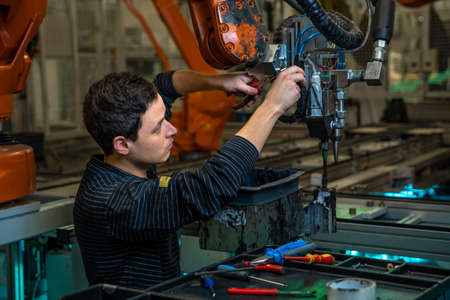 Modification of the robot to produce a new product. technically, the worker adjusts the machine....