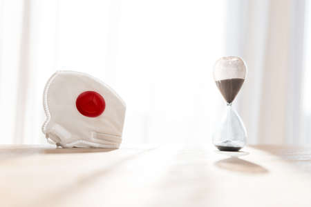 coronavirus and time, hourglass and respirator as a symbol of gaining time for managing the disease