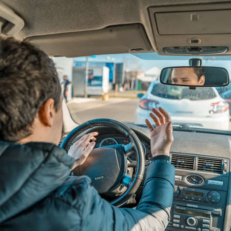 a man uses a horn in a car upset from a traffic jam in the city.