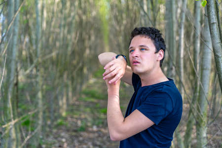 man phoning in the woods with the help of a smart watch