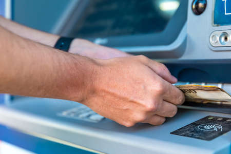 Withdraw cash from an ATMの写真素材