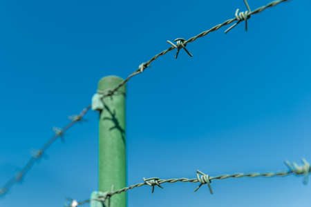 fence of barbed wire with blue sky in the background. copy spaceの写真素材