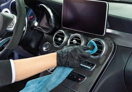 manual cleaning of the interior of luxury cars with a microfiber cloth