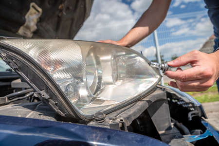 car headlight repair by replacing bad bulbs with new onesの写真素材