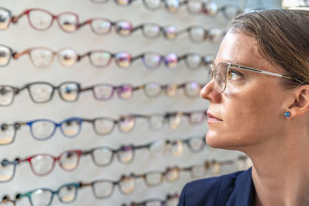 the glasses are selected and tested by a woman in an optics store. copy space