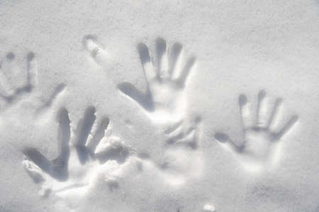 handprints on white snow in winter