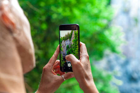 young woman shooting nature video with smartphoneの写真素材
