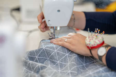 sew dressed on a sewing machine at home and in the studioの写真素材