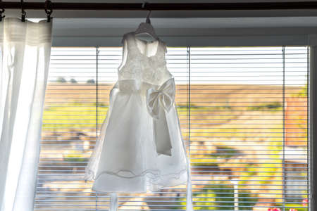 children's wedding dress hanging on window cornices.の写真素材