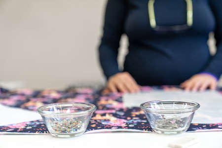 needles in a bowl on a sewing table in a tailor shop