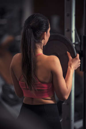 pretty young fitness woman at the gym on a fitness machineの写真素材