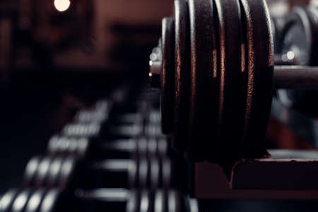 metal dumbbells of various weights on a gym shelfの写真素材
