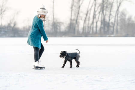 young woman and dog on a frozen lake in winterの写真素材