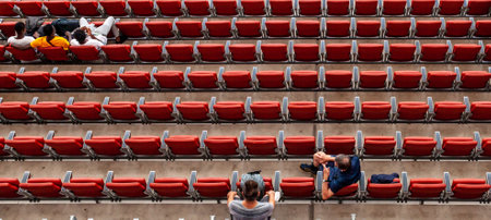 spectators at the stadium in red seats are watching the matchの写真素材