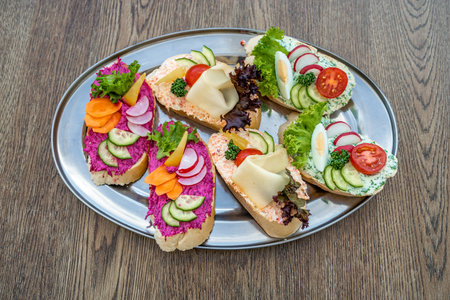 a variation of bread with a spread of cheese, egg and vegetablesの写真素材