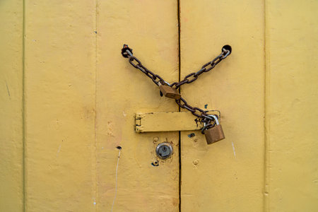 chain lock on the wooden yellow door. copy spaceの写真素材
