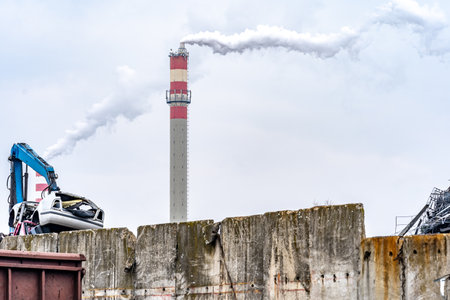a stack of iron loaded on a train and a smoking chimney