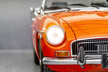 the shining front light of a red historic convertibleの写真素材