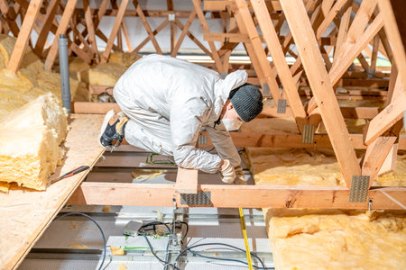 a worker in protective overalls works with glass woolの写真素材