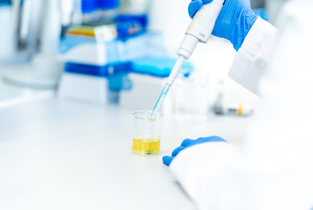pipetting a chemical sample into research glass flasks