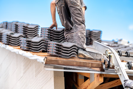 contractor builder laying fired ceramic tiles on the roofの写真素材
