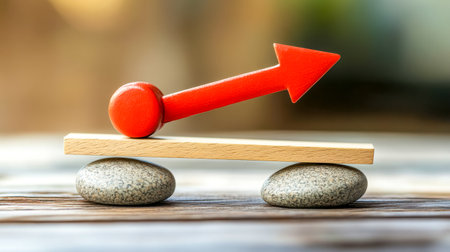 Red arrow balancing on wooden seesaw on stonesの素材