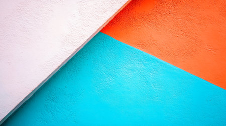 Abstract background of a rough textured wall being painted in white, orange and blueの素材