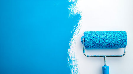 Paint roller applying fresh blue paint to white wallの素材