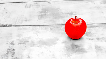 Shiny red apple sitting on grayscale wooden tableの素材