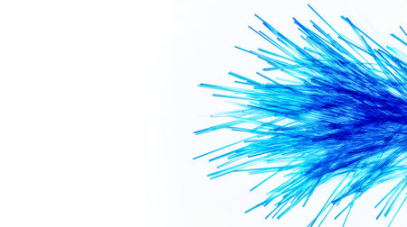 Numerous fiber optic cables create a vibrant blue burst of light against a clean white backdrop, symbolizing the power and speed of modern telecommunications technologyの素材