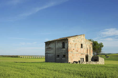 An old building on a green field with a bridge on backgroundの写真素材