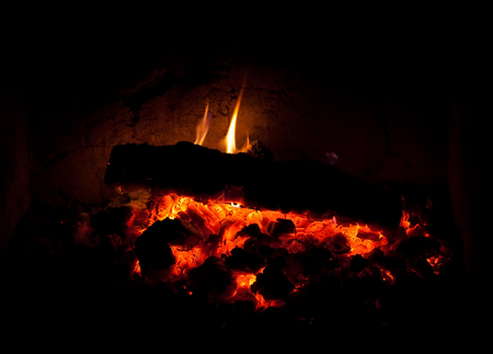 Photo of charcoal burning in the fireplace at nightの写真素材