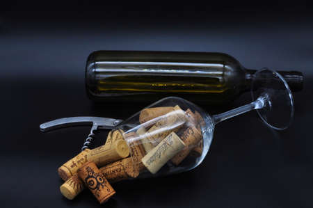 Wine glass full of many overturned corks taken from above isolated on black backgroundの写真素材