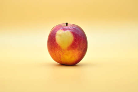 surprise apple with a natural heart appeared on the peel isolated on neutral background