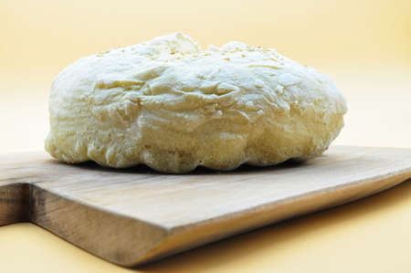 composition of a freshly baked handmade bread placed on an elegant wooden cutting board