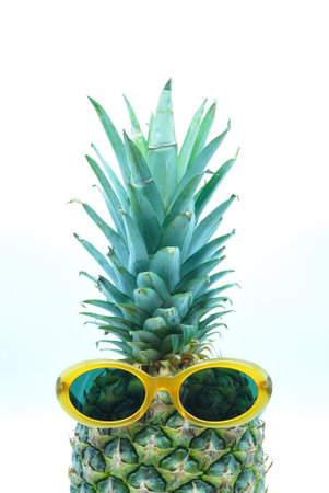 Fashion pineapple with sunglasses on a white background, summer holidays, vacation and food concept