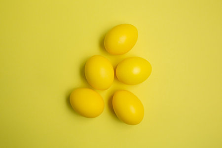 Easter yellow eggs on a yellow background. Top view. Happy Easter. Minimal concept.の写真素材