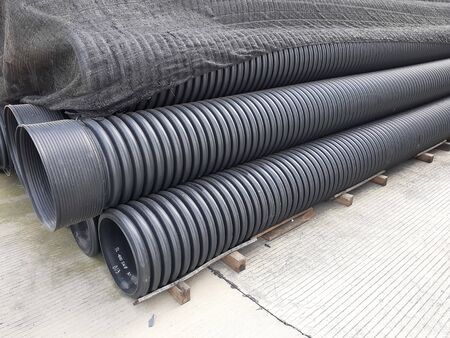 HDPE double wall corrugated pipes. Pipes stock are covered by tarpaulins to protect it from the weather effects.の写真素材