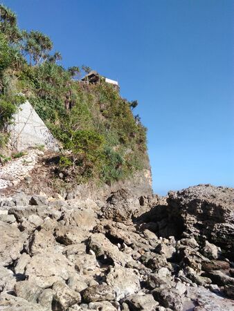 Shack on a coastal hill. Rocky hill on a sunny day in Gunung Kidul, Indonesia.の写真素材