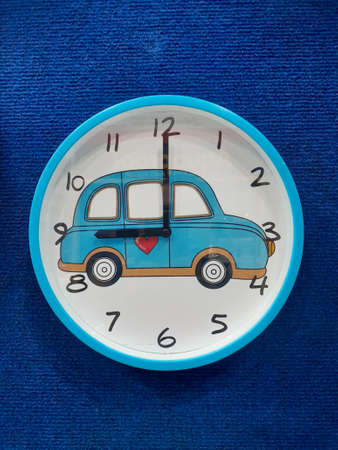 Cartoon car style wall clock. Simple design of wall clock set on blue background.の写真素材