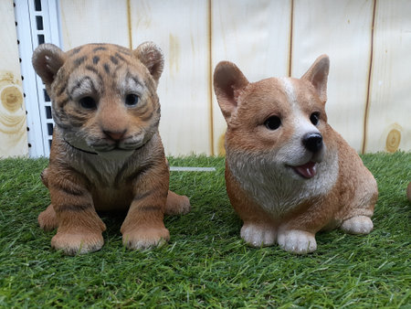 Statuary baby tiger and dog on the grass.の写真素材