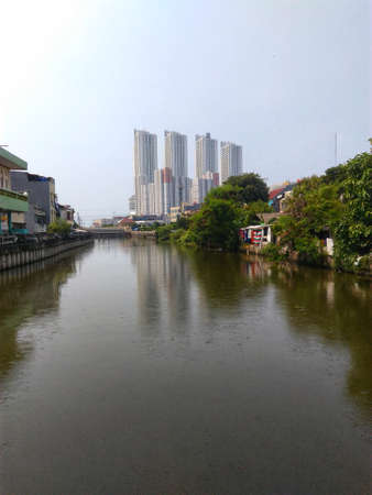 Jakarta, Indonesia - May 3, 2019: Panoramic view of the river flanked by settlements during the day. Pluit reservoir river in North Jakarta.のeditorial素材