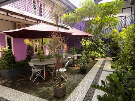 Exterior cafe in the middle of the hotel building. Outdoor cafe with a green atmosphere full of plants.のeditorial素材
